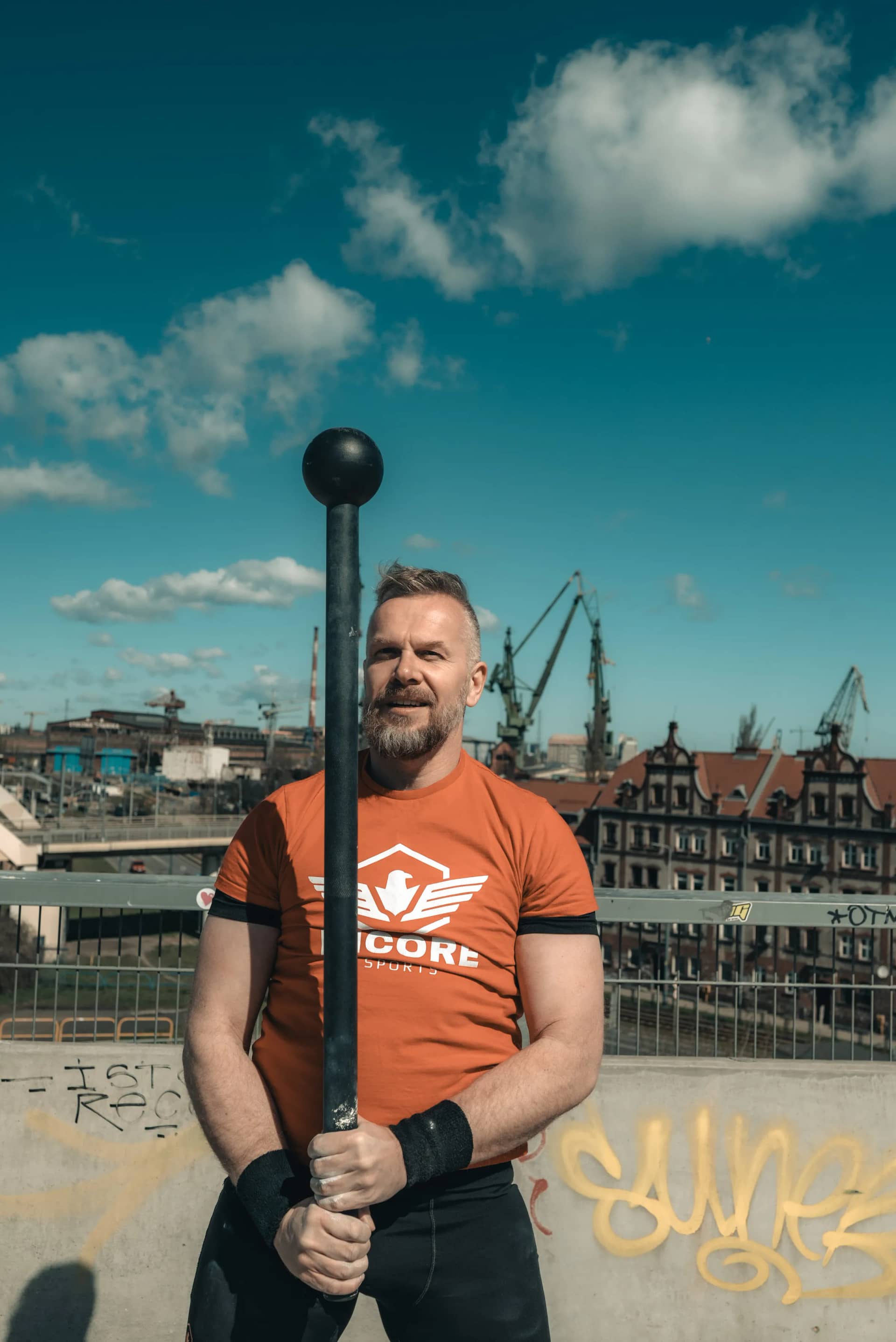 Athlete holding an Incore Sports macebell at the shipyard