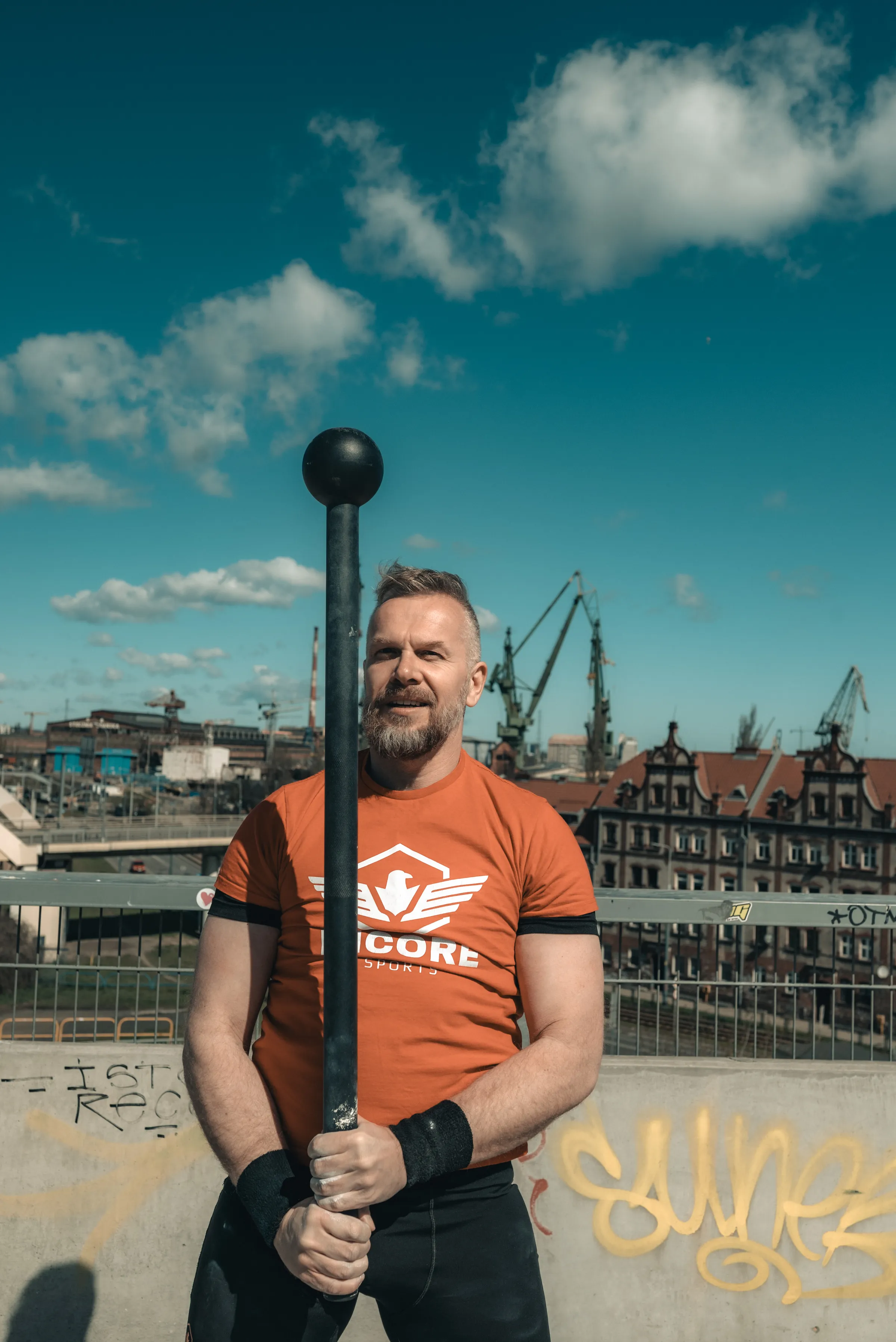 Athlete holding an Incore Sports macebell at the shipyard